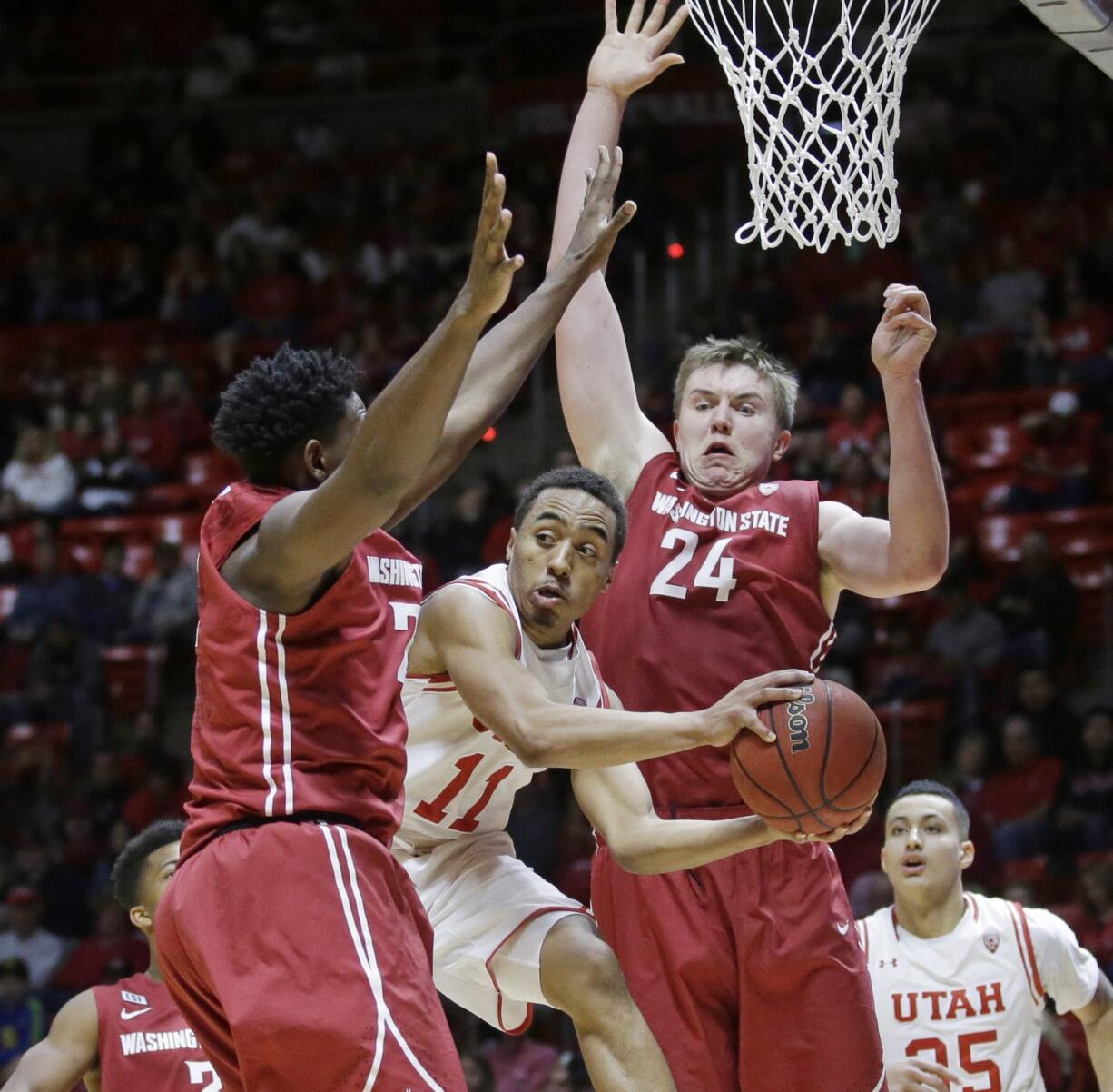 Utah guard Brandon Taylor (11) passes the ball as Washington State's Robert Franks, left, and Josh Hawkinson (24) defend during the second half in an NCAA college basketball game Sunday, Feb. 14, 2016, in Salt Lake City. Utah won 88-47.