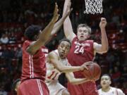 Utah guard Brandon Taylor (11) passes the ball as Washington State's Robert Franks, left, and Josh Hawkinson (24) defend during the second half in an NCAA college basketball game Sunday, Feb. 14, 2016, in Salt Lake City. Utah won 88-47.