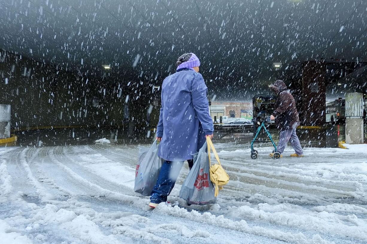 A woman walks across a road during a snowstorm Friday in New Bedford, Mass. What started off as rain Friday morning quickly turned to sticky, heavy snow. Many school districts in the region closed for the day, including in some in Massachusetts, New Hampshire and Rhode Island.