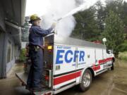 Volunteer firefighter Frank Billington goes through a routine check on the county mini pumper in 2015 at Station 96 in Bear Prairie, where he lived with his family for the last seven years before the district&#039;s board voted to sell the property at a meeting in January.