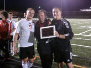 Camas High School soccer coach Roland Minder celebrates his 250th victory with seniors Drew White (left) and Zach Anderson (right).