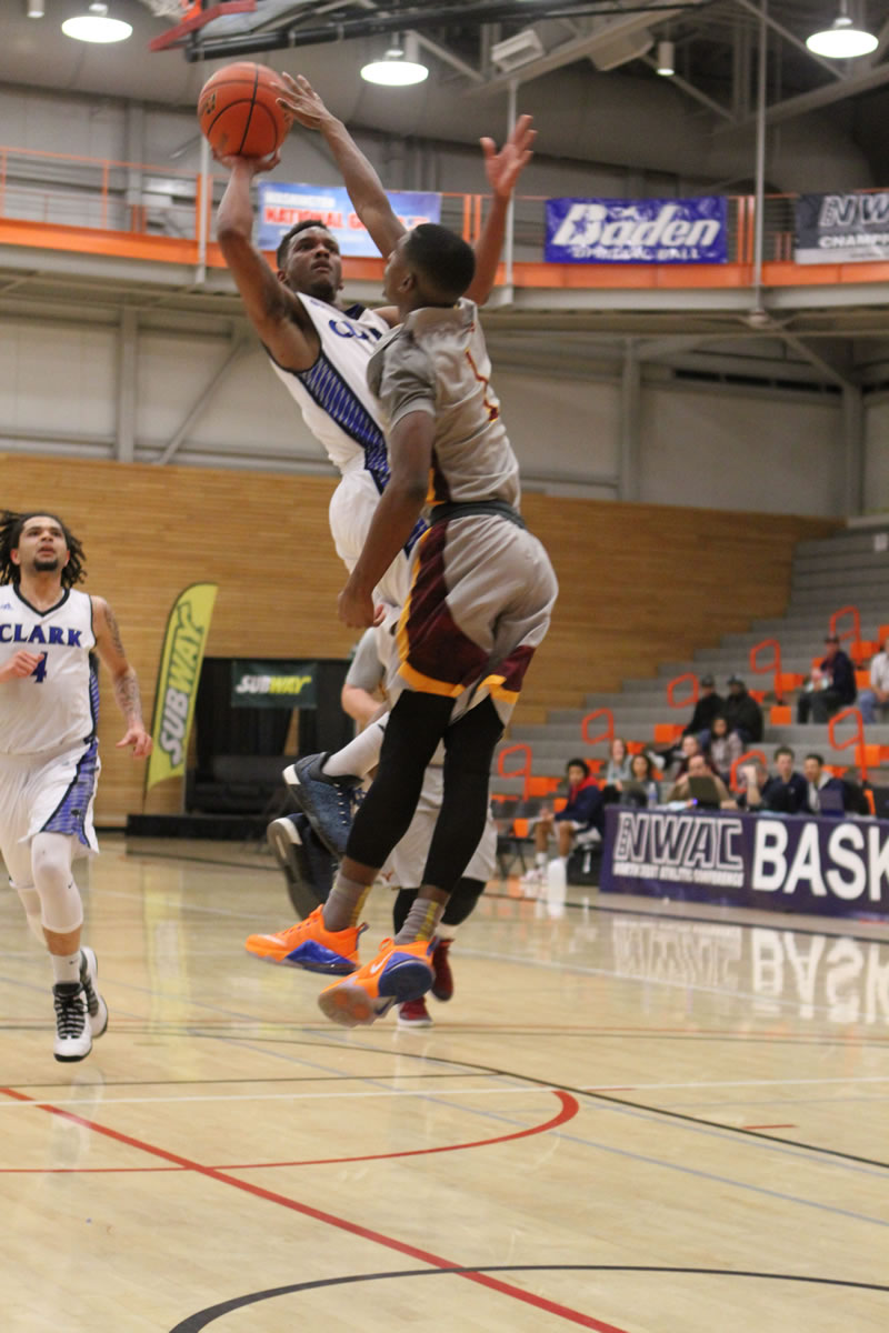 Clark College&#039;s Darrius Mathis, center, attempts a shot against Yakima Valley in the Northwest Athletic Conference tournament quarterfinals Friday at Everett Community College. Clark won 65-57.