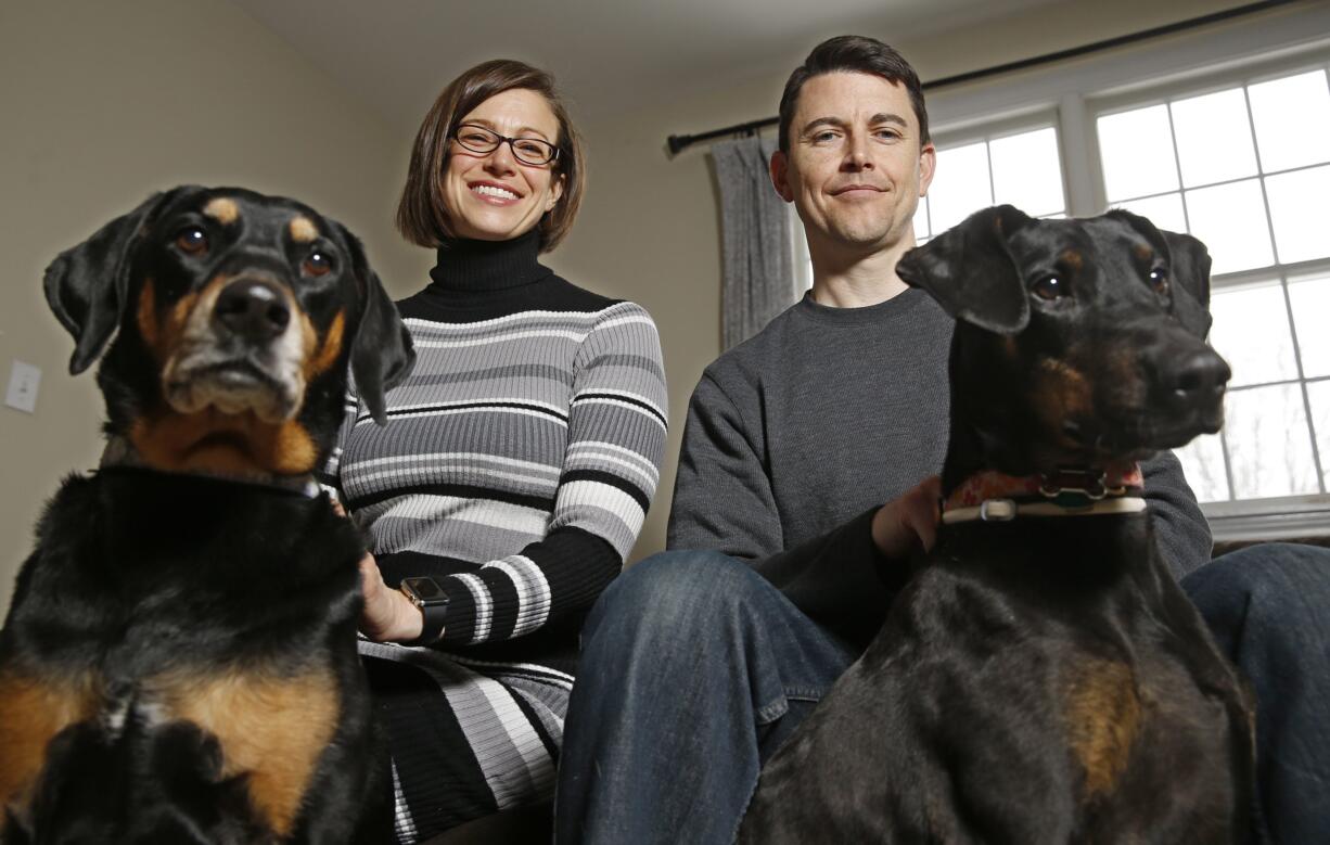 Julie Sanders, left, and her husband Cory Donovan, seen with their dogs, Raven, left, and Lula, created a new phone app, Fur Alert, that alerts subscribers if a fellow subscriber has lost a dog or cat in their area.