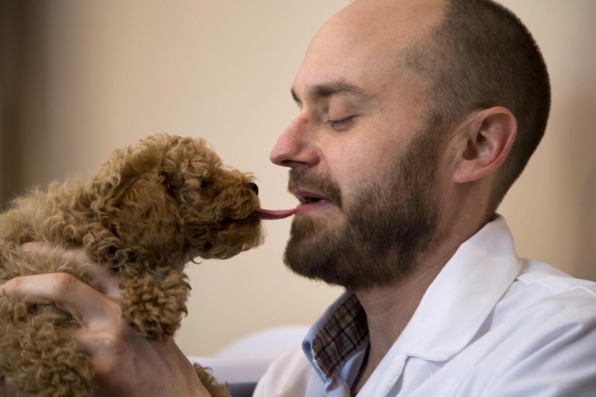 Veterinarian Dr. Dominic Dallago gets a kiss from 13-month old Oliver, a Maltese poodle, in an exam room at World of Animals Veterinary Hospital in Philadelphia on March 4. Dallago says he has suffered from pet allergies and asthma since childhood.