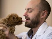 Veterinarian Dr. Dominic Dallago gets a kiss from 13-month old Oliver, a Maltese poodle, in an exam room at World of Animals Veterinary Hospital in Philadelphia on March 4. Dallago says he has suffered from pet allergies and asthma since childhood.