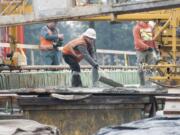 Construction workers pour concrete at the Interstate 205-N.E. 18th Street interchange project bridge deck on Jan. 7 in Vancouver. The Department of Ecology is fining project contractor Cascade Bridge for allowing runoff into Burnt Bridge Creek.