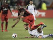 Portland Timbers forward Fanendo Adi (9) is tackled by Real Salt Lake midfielder Kyle Beckerman (5) during the first half of an MLS soccer game at Providence Park in Portland, Ore., Saturday, March 19, 2016.