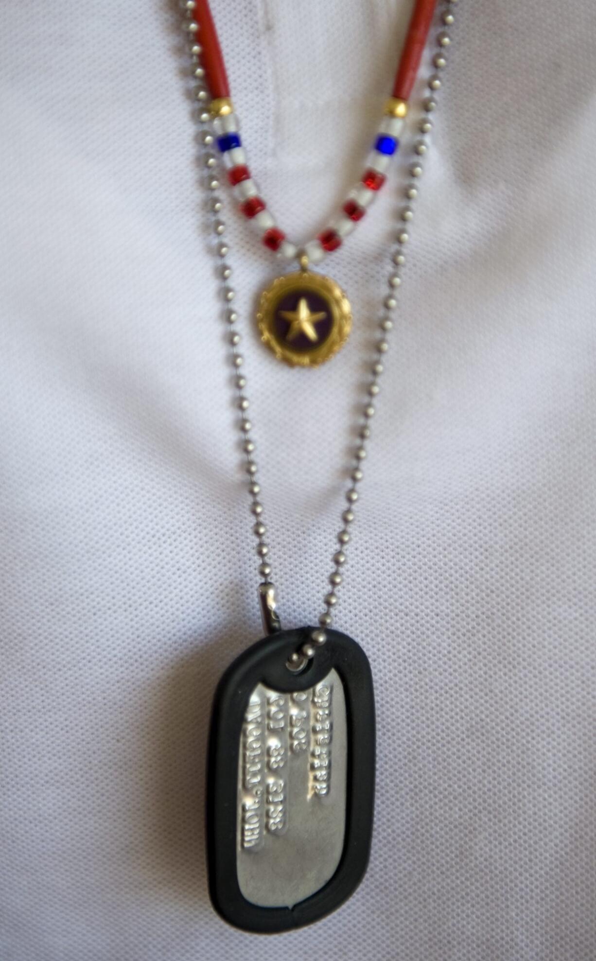 While staffing a fundraising fireworks booth in 2009, Colleen Czaplicki wears a Gold Star pin and the ID tags of her son Sgt. John Kyle Daggett, who died in 2008.