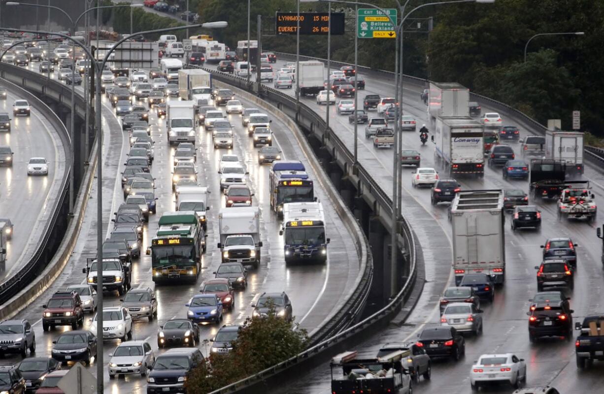 Traffic creeps along toward downtown Seattle on Interstate 5, left, and heading out during a rainy morning commute in September 2014.