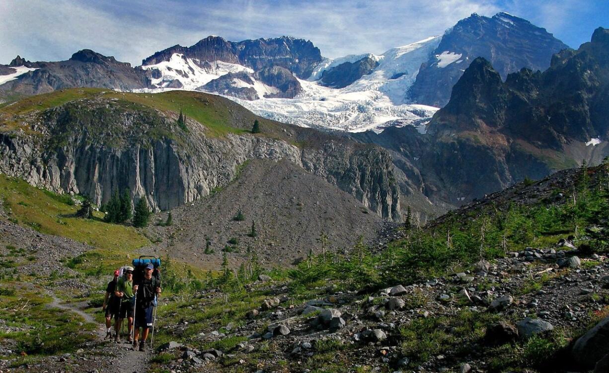 Thad Richardson, right, Matt Misterek and Craig Hill hike on Emerald Ridge on the Wonderland Trail at Mount Rainier National Park in 2012.  Because of a computer glitch, wilderness permits for the Mount Rainier National Park will be distributed on a first-come, first-served basis.