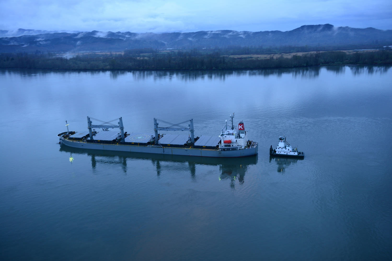 A tug helps stabalize the motor vessel Sparna, a 623-foot Panamanian-flagged bulk carrier, while the Sparna awaits repairs after it reportedly ran aground in the Columbia River near Cathlamet, Wash., March 21, 2016. The Sparna is loaded with grain and was headed west on the Columbia River when the incident occurred. (U.S.