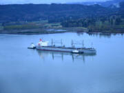 Two tugs assist the motor vessel Sparna, a 623-foot Panamanian-flagged bulk carrier with a load of grain, after the vessel reportedly ran aground in the Columbia River near Cathlamet, Wash., March 21, 2016. A salvage plan must be approved by the Coast Guard before the vessel can be refloated. (U.S.