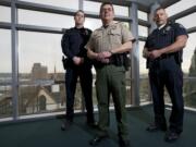 Portland Police Sgt. Peter Simpson, from left, Clark County Sheriff's Deputy Tim Hockett and Vancouver police Officer Taylor Smarr pose for a portrait inside the Clark County Public Service Center in February 2013. The Vancouver Police Department, Clark County Sheriff's Office and Portland Police Bureau had just announced plans to use one central records management system that would allow officers to easily access information from other agencies. The sheriff's office is now saying the system isn't worth the hassle.