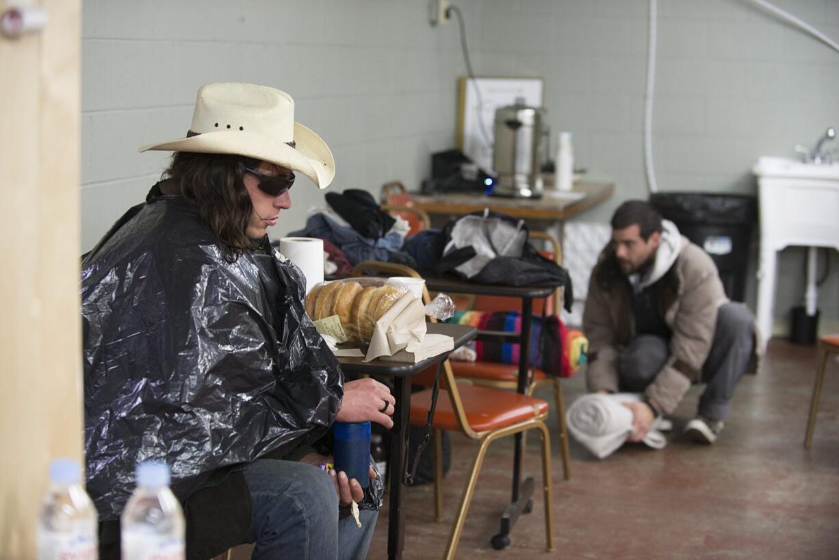 At Friends of the Carpenter&#039;s day center for the homeless in west Vancouver, client James Patterson, left, takes a moment to get out of the rain and wind Wednesday afternoon as John Welton, background, organizes his belongings. Share operates the facility.