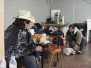 At Friends of the Carpenter&#039;s day center for the homeless in west Vancouver, client James Patterson, left, takes a moment to get out of the rain and wind Wednesday afternoon as John Welton, background, organizes his belongings. Share operates the facility.