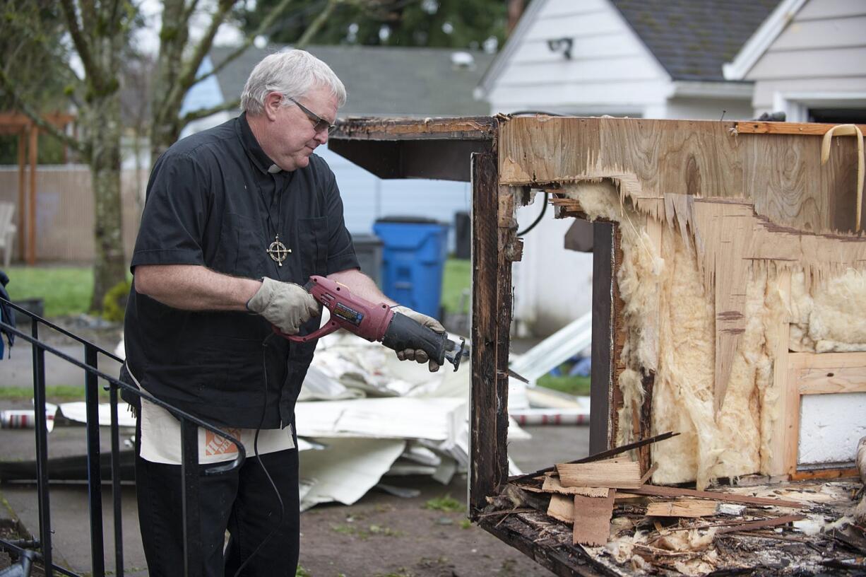 The Rev. David Knudtson of Arnada Abbey takes apart a trailer that will be converted into mobile showers.