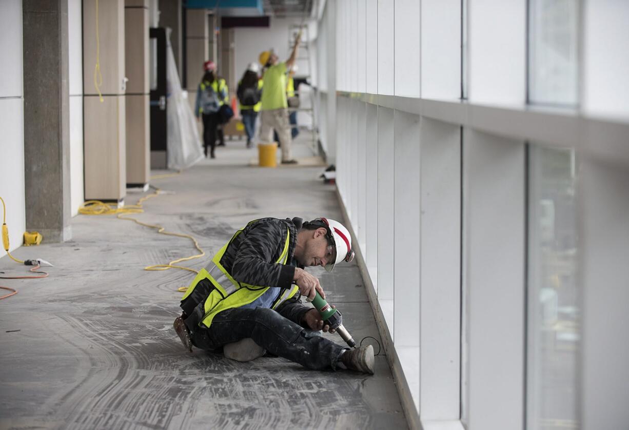 Mark Adams of Adams Interiors heat seals the chemical-resistant floor outside the chemical storage room in the new STEM Building on Thursday morning at Clark College.