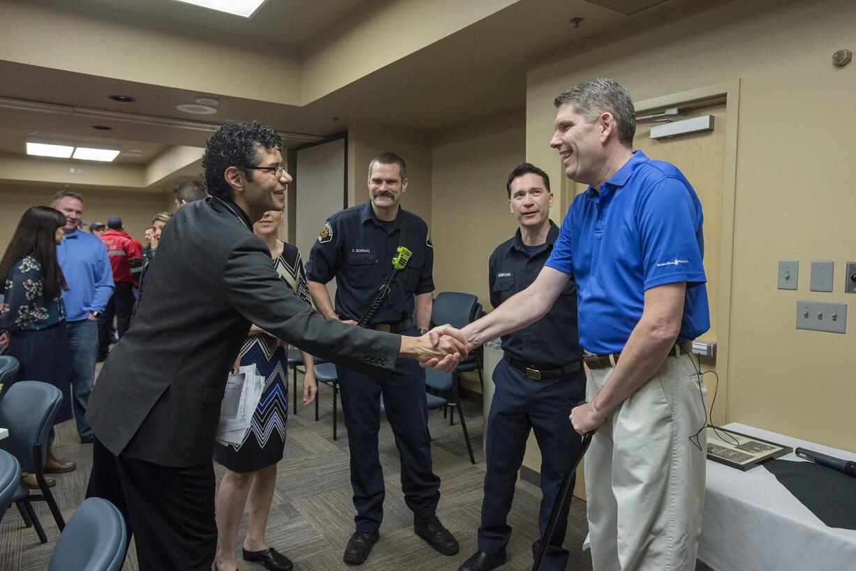 Dr. Jaime Nicacio, left, greets his former patient, Rick Jarvis of Camas, as Jarvis&#039; wife, Charlotte, firefighter Obie Bowman, right of her, and paramedic/firefighter Brian Quintana, right of Bowman, look on during a case review Thursday morning at PeaceHealth Southwest Medical Center. Rick Jarvis attended the case review to personally thank the first responders and medical providers who cared for him after an October car wreck.