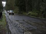 Motorists rumble over a rough stretch of Evergreen Highway near the intersection of Southeast 113th Court on Monday afternoon.