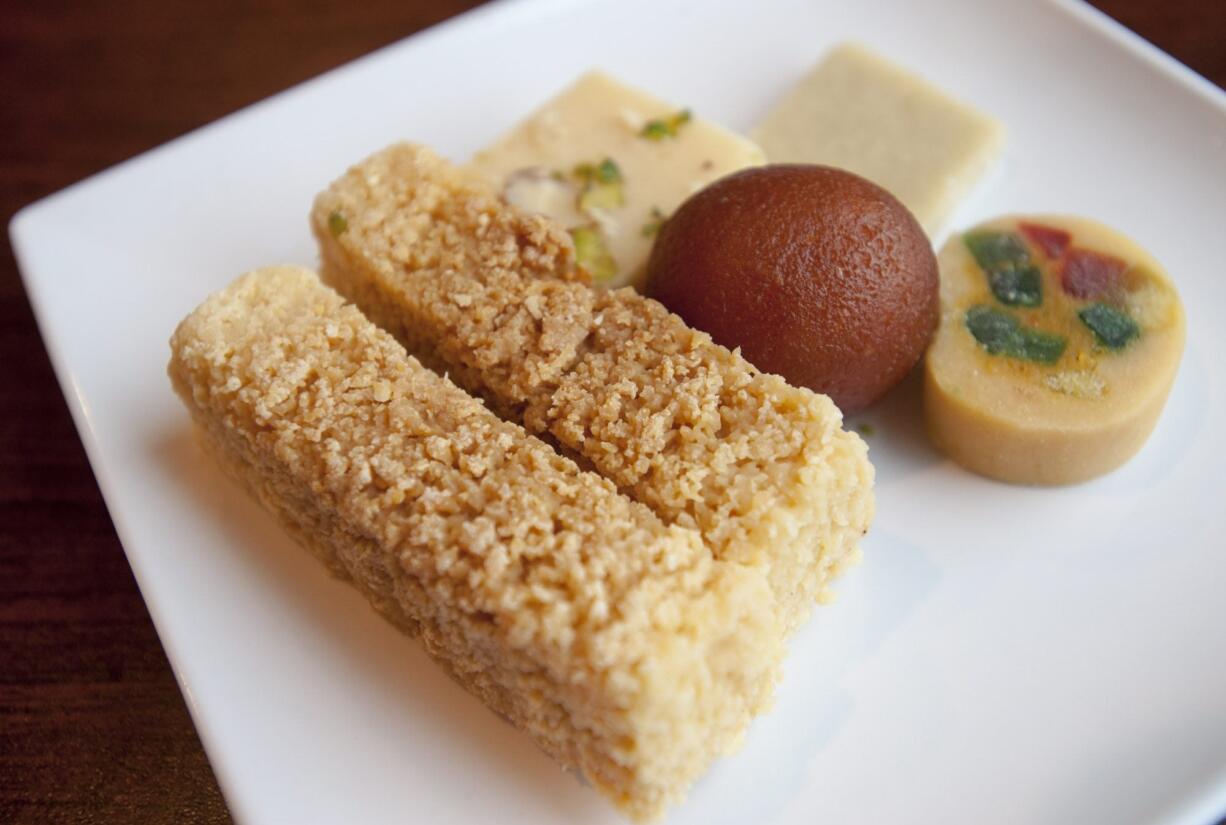 Milkcakes, left, are served with other sweets at Guru Sweets on Mill Plain n Vancouver.