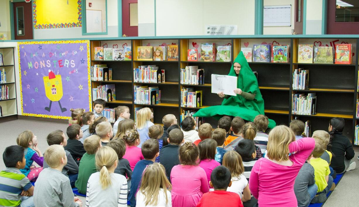 Woodland: Shae Lindsay, school librarian, wears a tree costume while reading &quot;The Giving Tree&quot; to students as part of the Reading is Fundamental Program.