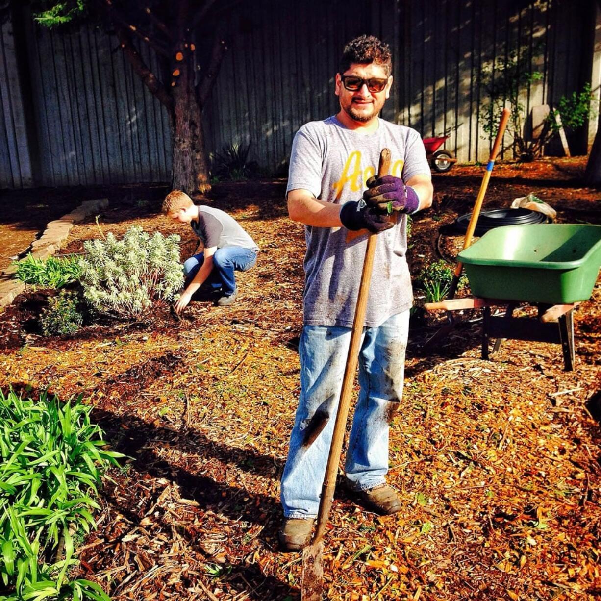 David Malagon-Lopez spreads bark chips while Adam Lindberg weeds in the Butterfly/Hummingbird Garden.