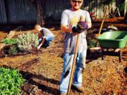 David Malagon-Lopez spreads bark chips while Adam Lindberg weeds in the Butterfly/Hummingbird Garden.