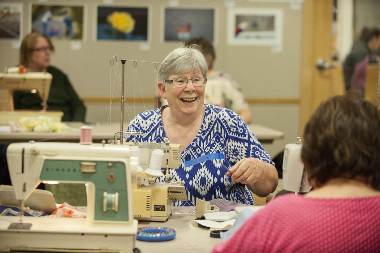 Janice Tope of Vancouver, center, shares a laugh with friend Phyllis McIntosh while sewing at Three Creeks Community Library.