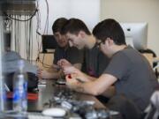 Juniors Cody Henderson, from left, Raoul Russ and Mitchell Russum work on circuitry for an ozone sensor Friday at Washington State University Vancouver.