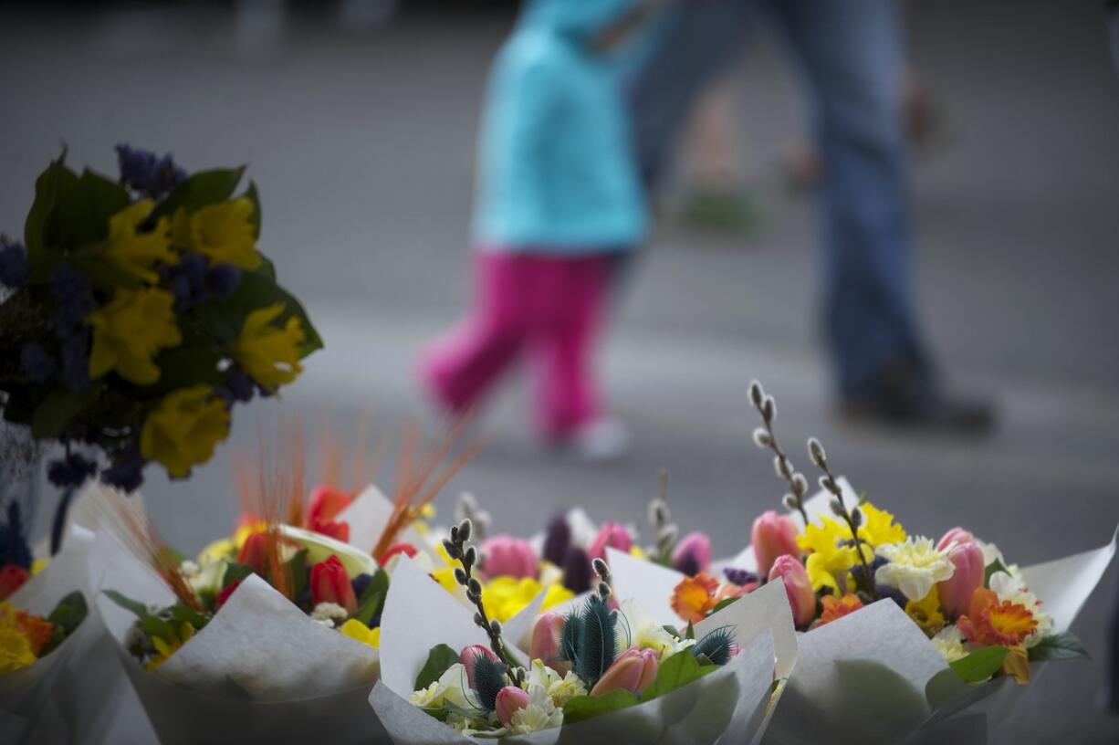 Kia Lor of C&amp;K&#039;s Flower Garden puts together a bouquet for a customer during the opening weekend of the Vancouver Farmers Market in 2014.