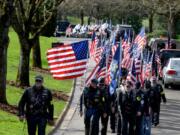 Hazel Dell: Members of Patriot National Guard honor two unclaimed soldiers by holding American flags during funeral procession.