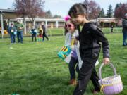 Angel Miller-Boyko, left in glasses, and Jasmine Eiland, both 7, search for Easter eggs at the Beeping Easter Egg Hunt for the Blind on Saturday morning.