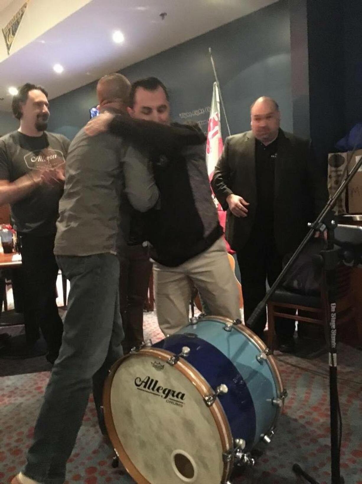 Fisher&#039;s Landing East: Marcus Young, from left, of Allegra Drums watches as Washington State Patrol Trooper Pete Stock gets a hug from Paul Godin.