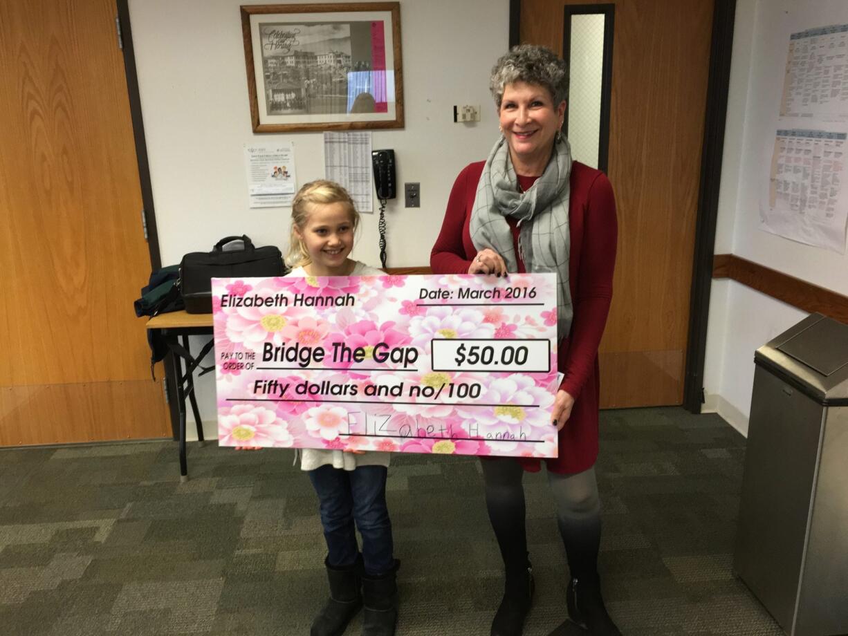 Hazel Dell: Elizabeth Hannah left, presents a check to Lynn Miller, board chair of Bridge the Gap.