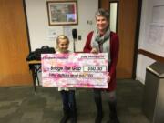 Hazel Dell: Elizabeth Hannah left, presents a check to Lynn Miller, board chair of Bridge the Gap.