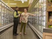 Vancouver New Seasons Market manager Glen Jones, left, and the store&#039;s Green Team captain Makayla Karlsen look over energy-saving doors at the store, which was recognized Thursday evening by the Clark County Green Business Program as the Green Business of the Year.