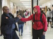 Tony Jacobs, left, the &quot;singing security guard&quot; at Fort Vancouver High School, greets freshman Rickie Williams, 15, in the hallway.