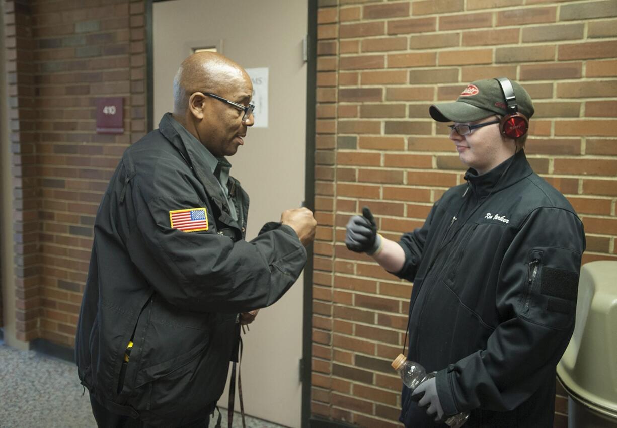 Tony Jacobs, the &quot;singing security guard&quot; at Fort Vancouver High School, shares a fist bump with sophomore Darren Barker, 17, on March 14.