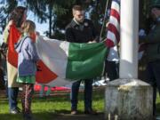 Patrick Lane-Klein, center, helps link an Irish flag on the halyard below the American flag Thursday as the family of Denny Lane continues an 80-year-old tradition.