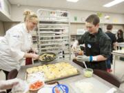 Skyridge Middle School eighth-grader Gage Gywnn gets some help from Robin Boespflug as he assembles samples of his recipe, &quot;Breakfast Taco,&quot; for the Future Chef contest Tuesday afternoon at Camas High School. Gage took home the top prize for his heart-healthy breakfast dish.