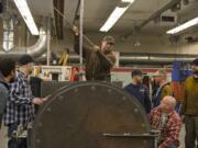 Brandon Snow, top, a welding and fabrication technology program student at Clark College, checks the pressure vessel&#039;s water depth while working with fellow students March 9.