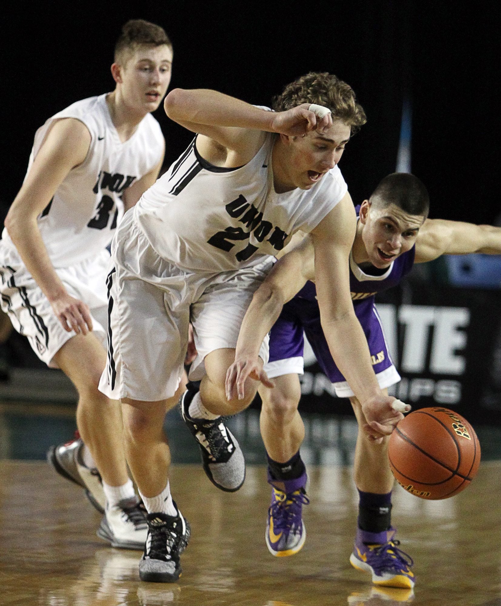 Union's Nico Bricker (21) steals the ball away from Issaquah's Trevon Ary-Turner (5) in the closing minute in the 2016 WIAA Boys 4A Hardwood Classic State Basketball 4th place game held in the Tacoma Dome on March 5, 2016.  Bricker passed the ball to teammate Keithan Shepard, who, layer the ball up to give Union the lead over Issaquah. Union beat Issaquah 60-57 for the 4th Place trophy.