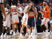 Gonzaga&#039;s Josh Perkins (13) walks off the court as Syracuse players celebrate after a college basketball game against Syracuse in the regional semifinals of the NCAA Tournament, Friday, March 25, 2016, in Chicago. Syracuse won 63-60.