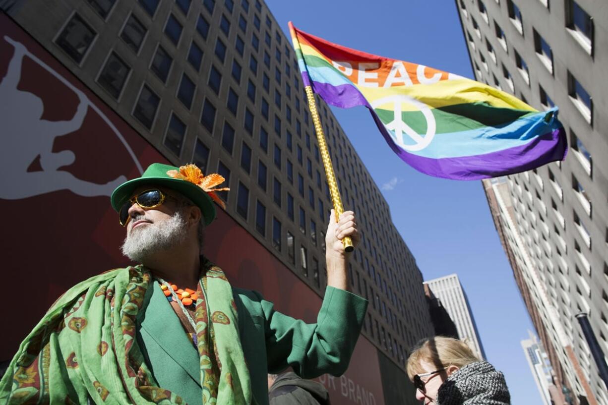 Steven Menendez waves a gay pride flag as he waits for the St. Patrick's Day parade to start on Fifth Ave, Thursday, March 17, 2016, in New York. The nation's largest St. Patrick's Day parade kicked off Thursday in New York City, and for the first time in decades, gay activists are not decrying it as an exercise in exclusion.