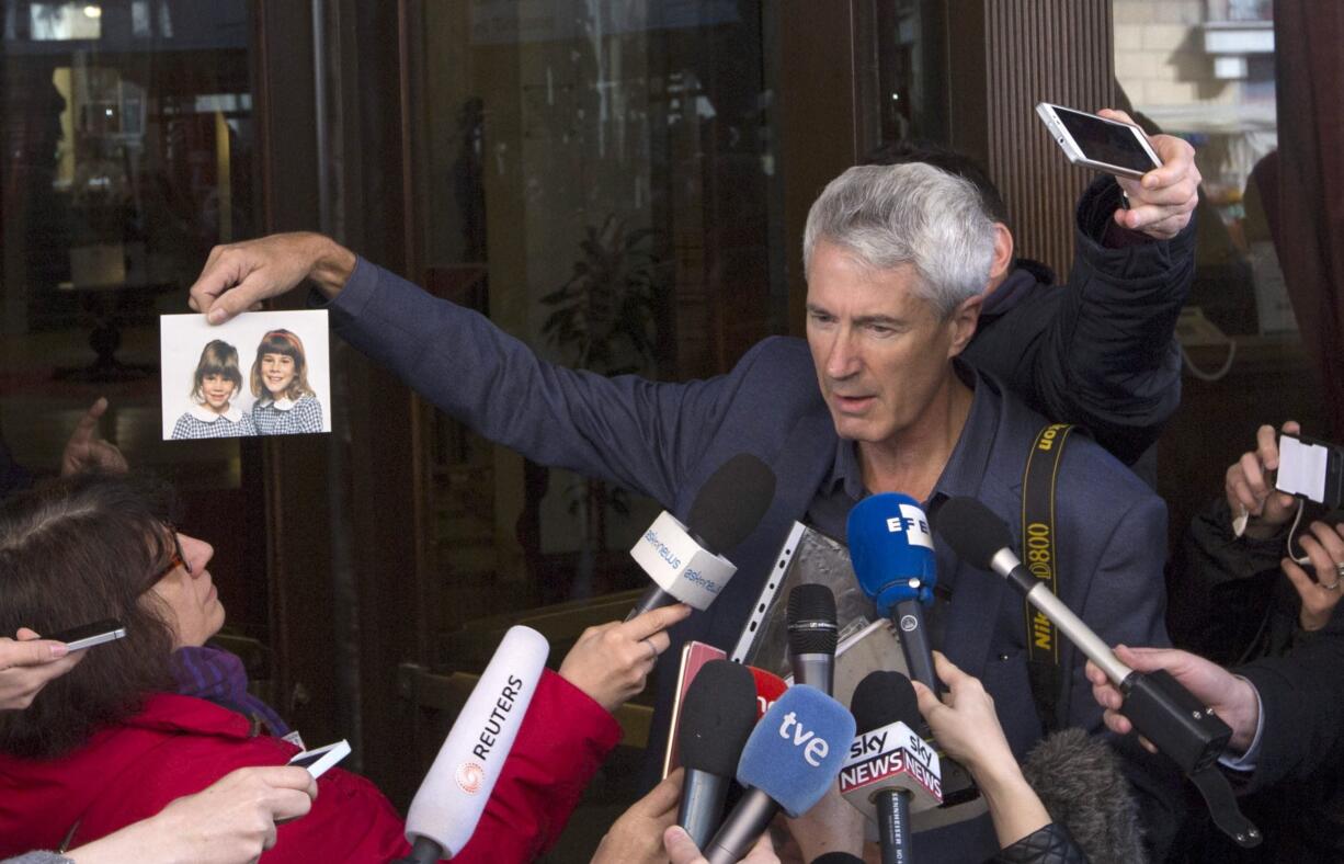 Anthony Foster, who is a member of an Australian group of priest sex abuse victims, shows reporters a photo of his two daughters on Thursday after a meeting with Australian Cardinal George Pell in Rome. Both girls were abused by the same priest and one of them committed suicide.