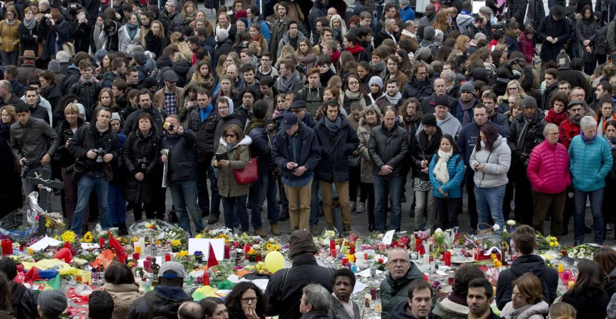 People gather to observe a minute of silence and mourn for bombing victims Thursday at the Place de la Bourse in the center of Brussels, Belgium.