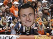 Fans hold a large cutout of Cleveland Browns quarterback Johnny Manziel during a Dec. 14, 2014, NFL football game against the Cincinnati Bengals, in Cleveland. The Browns have released troublesome quarterback Johnny Manziel. The team cut ties on Friday with the 2012 Heisman Trophy winner after two disappointing, drama-filled seasons. Manziel faces an uncertain future in the NFL and potential criminal charges in Texas following a domestic violence incident.