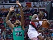 Portland Trail Blazers forward Al-Farouq Aminu, right, passes the ball away from Boston Celtics forward Amir Johnson, left, during the first half of an NBA basketball game in Portland, Ore., Thursday, March 31, 2016.