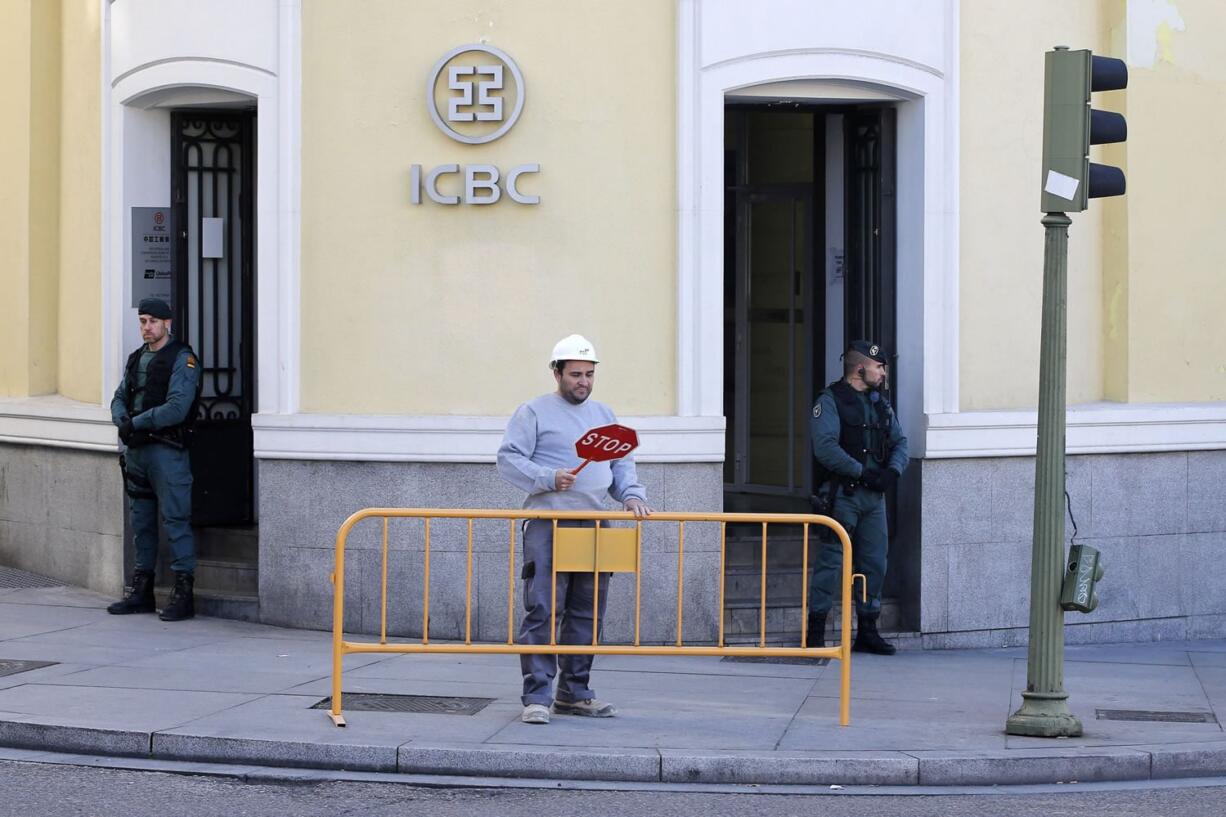 Spanish Civil Guards stand outside an Industrial and Commercial Bank of China, or ICBC, branch in Madrid, Spain.