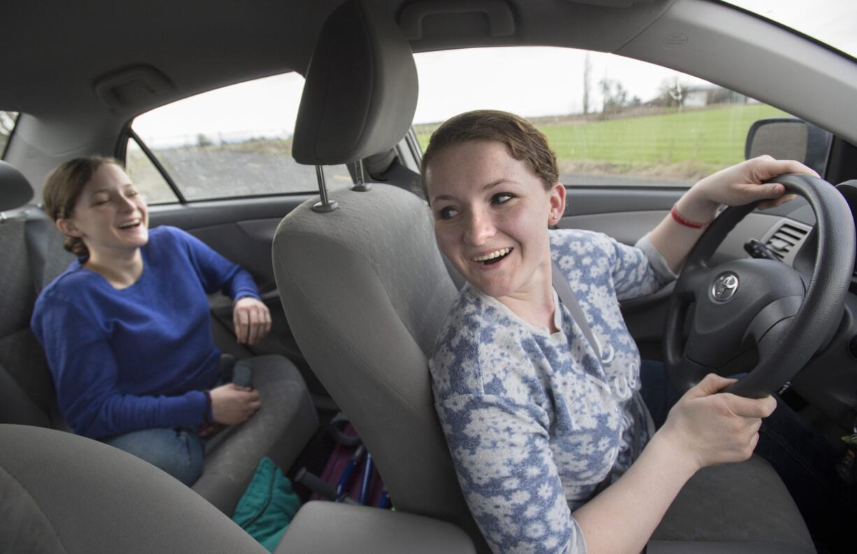 Kathleen Lincoln practices driving Dec. 24 as her sister Charity rides in the back seat on the country roads outside Harrisburg, Ore. Charity and Kathleen Lincoln spent their early years in the national spotlight. Conjoined at birth, intertwined through their abdomens and pelvises, the identical twins with curly, strawberry blonde locks hailed from Lacey and won America?s hearts on Sept. 30 and Oct. 1, 2000, when at just 7 months old, they underwent a complicated, nearly 30-hour separation surgery at Children?s Hospital in Seattle.